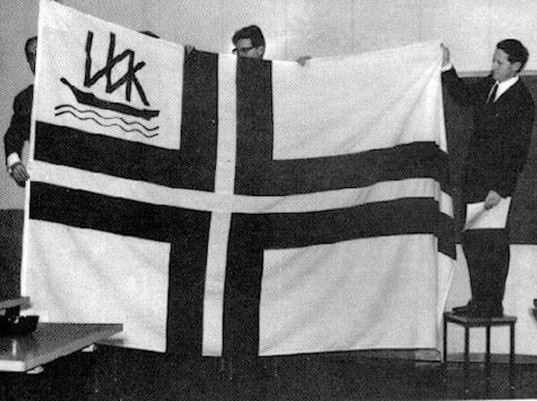 VVK:n lippu hyväksyttiin 1969. Vasemmalla sihteeri Erkki Iiskola, keskellä varakommodori Kaj Grûnn, oikealla Kommodori Henrik Blom.